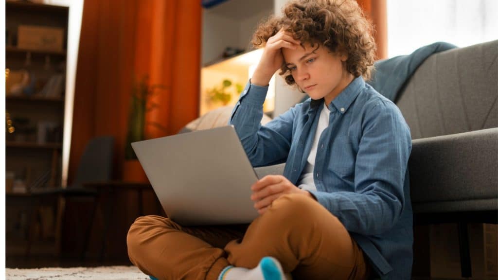 adolescente preocupado olhando tela do notebook