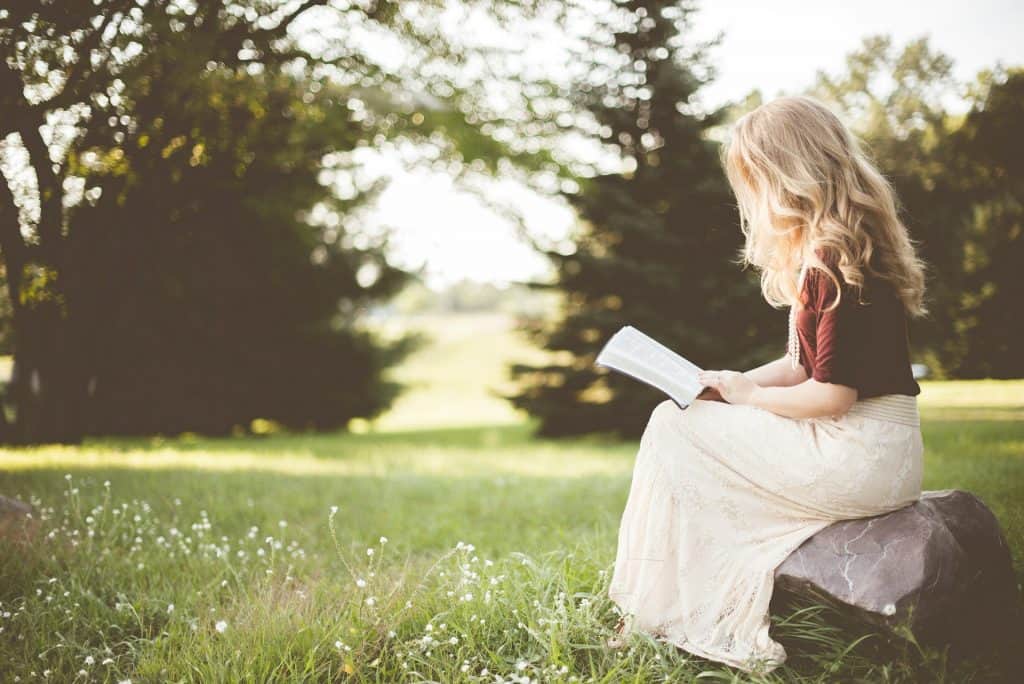 Mulher lendo via Ben White/Unsplash